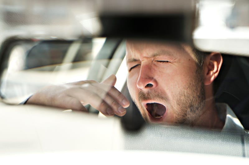 driver yawning, seen in mirror