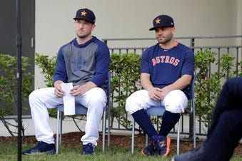 Houston Astros infielder Alex Bregman, left, and Jose Altuve sit in chairs as they wait to deliver statements during a news conference before the start of the first official spring training baseball practice for the team Thursday. (AP Photo/Jeff Roberson)
