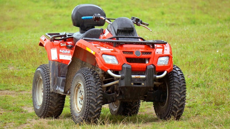 Red awd atv on green grass
