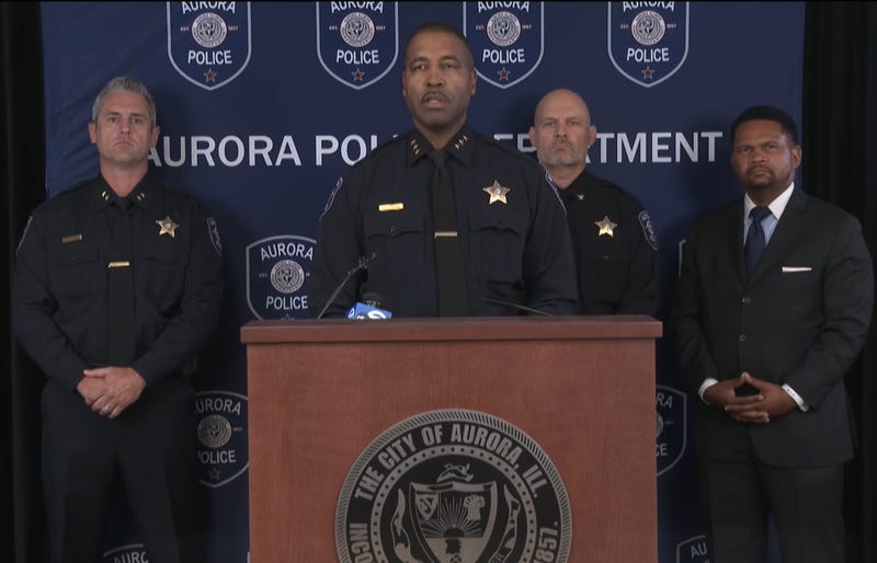 Aurora Police Chief Keith Cross speaking at podium 