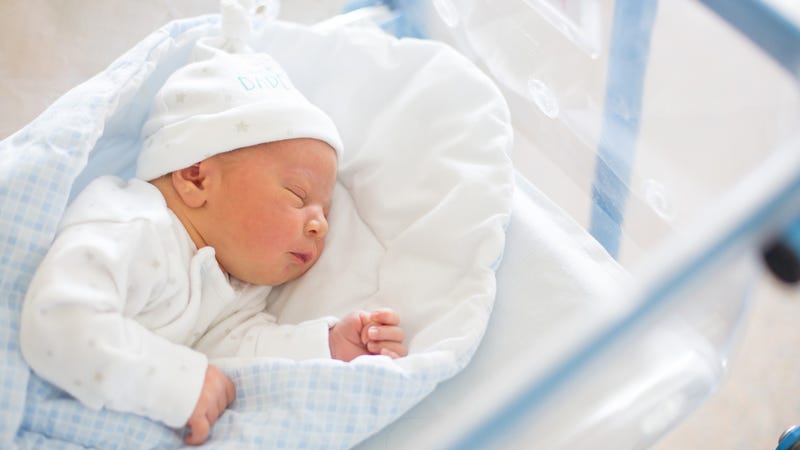 Beautiful newborn baby boy, laying in crib in prenatal hospital