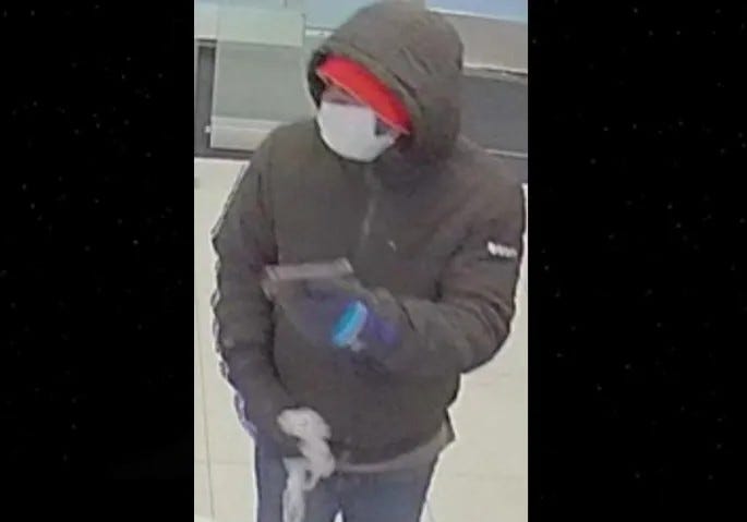 robbery surveillance photo of man with gun