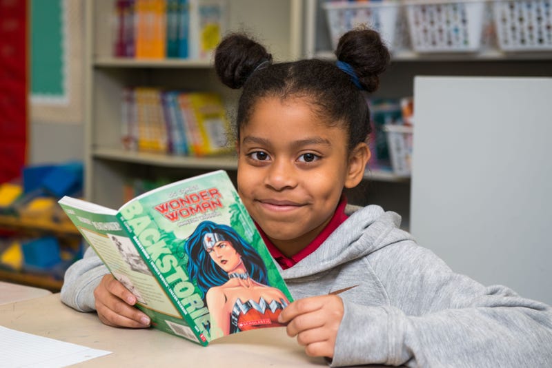 A child reads a book with Barbara Bush Literacy Foundation