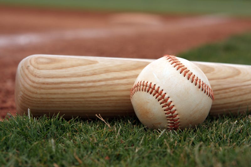 Close-up of baseball and bat resting on the field