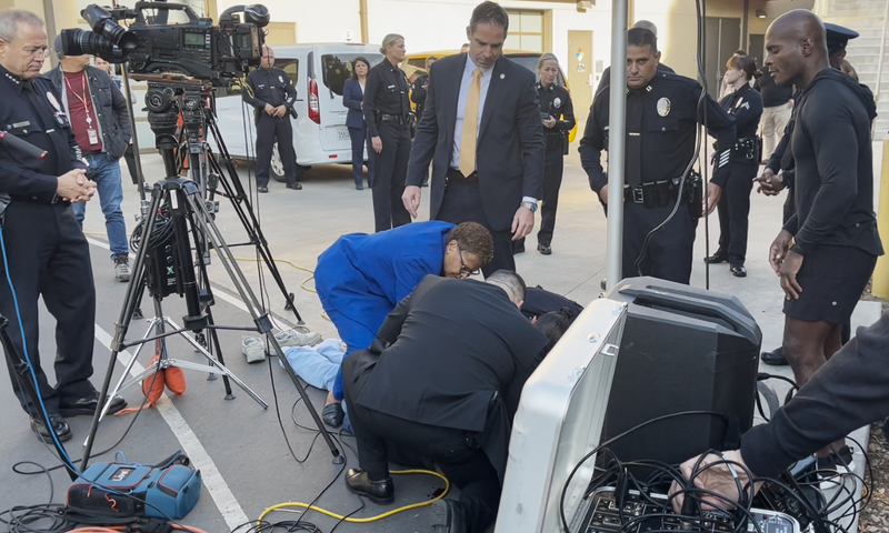 karen bass helps man lying on ground
