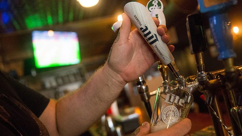 A bar tender pours a glass of Miller High Life beer at a bar on October 9, 2015 in New York City. Budweiser's parent company AB InBev is attempting to buy SABMiller. 