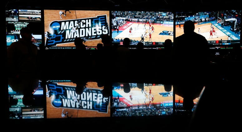 In this March 15, 2018 photo, people watch coverage of the first round of the NCAA college basketball tournament at the Westgate Superbook sports book in Las Vegas.