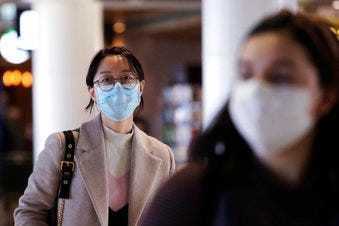 Travelers at Seattle-Tacoma International Airport wear masks Tuesday, March 3, 2020, in SeaTac, Wash. (AP Photo/Elaine Thompson)