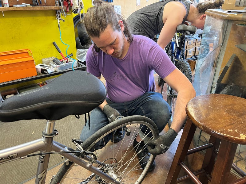 Bike Shop owner working on tire