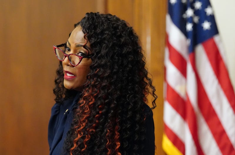 mayor tishaura jones wearing her red glitter glasses and in front of an american flag