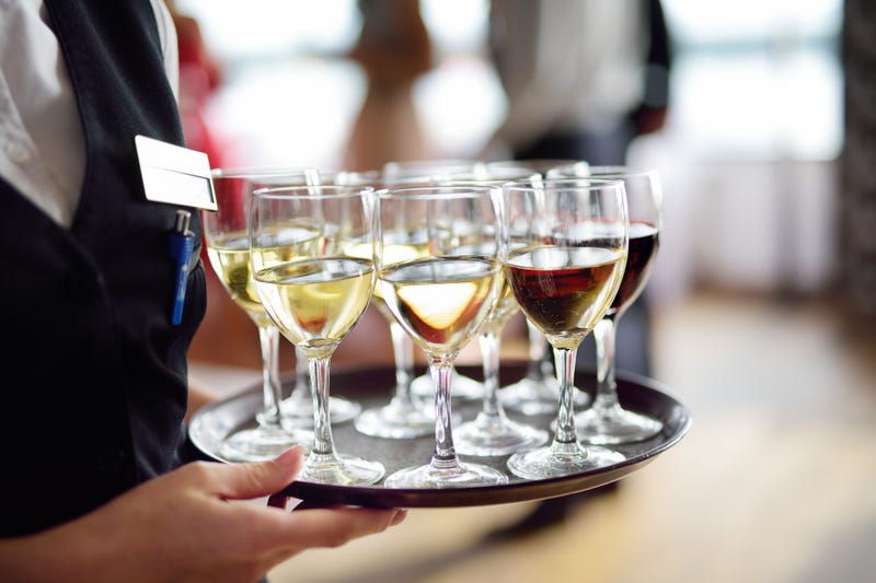 server with wine glasses on tray