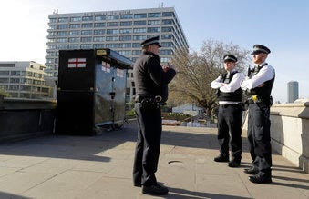 Police officers stand outside St Thomas' Hospital in central London as British Prime Minister Boris Johnson was moved to intensive care after his coronavirus symptoms worsened in London, Tuesday, April 7, 2020. (AP Photo/Kirsty Wigglesworth)