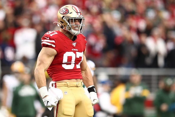 Nick Bosa celebrates on field with the 49ers. 