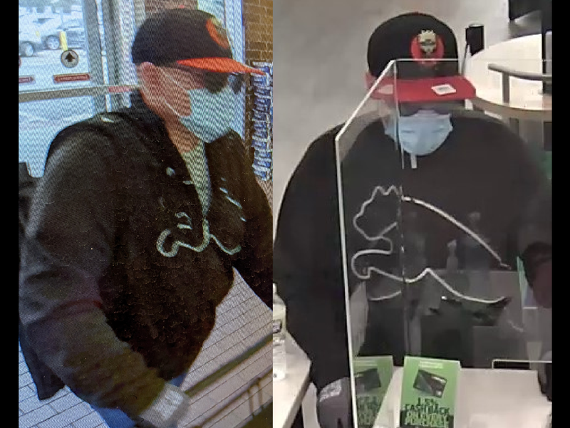 A man in a black sweatshirt and a black and red baseball cap stands in front of a bank teller window