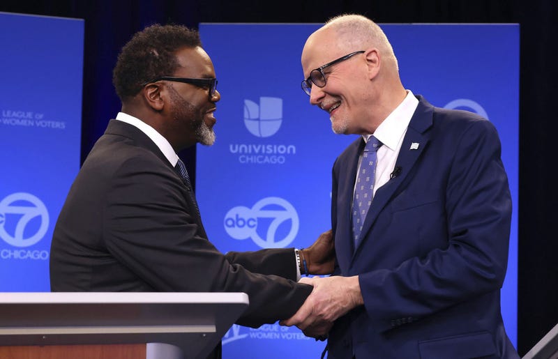 Brandon Johnson, Paul Vallas shaking hands at forum