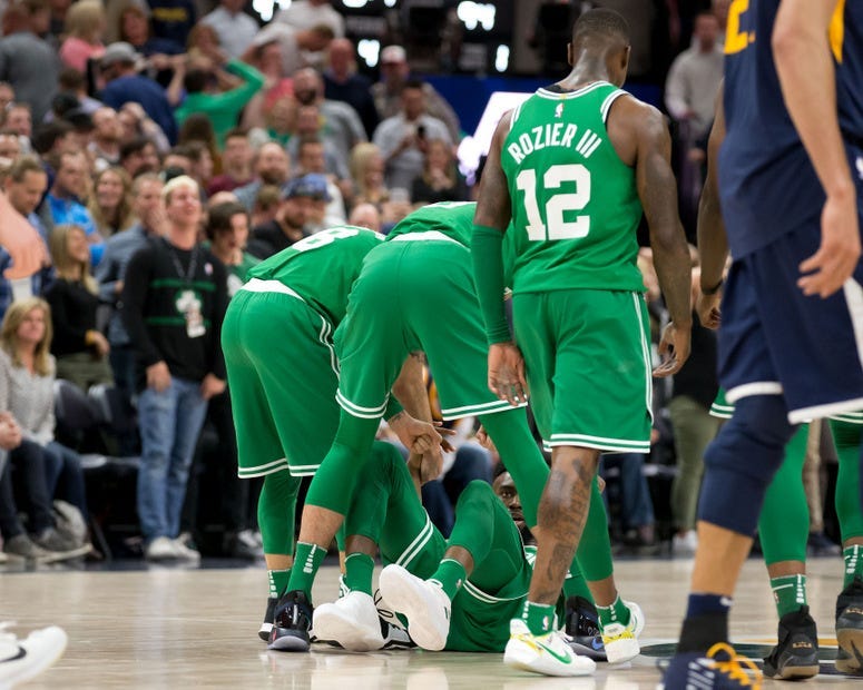 Celtics teammates surround Jaylen Brown after his game-winner against Jazz.