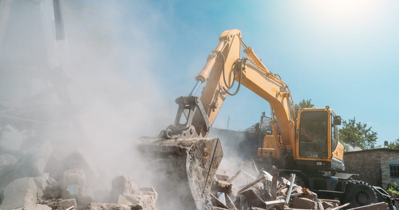 back hoe tearing through debris