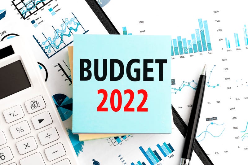 Text BUDGET 2022 on stickers. Pen and calculator on clipboard with charts, documents and graphs