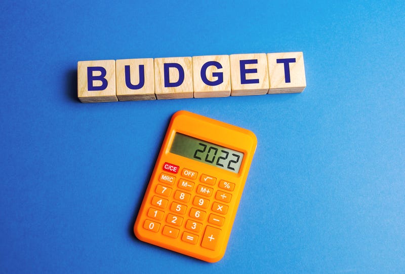 Wooden blocks with the word budget and a calculator with numbers 2022.