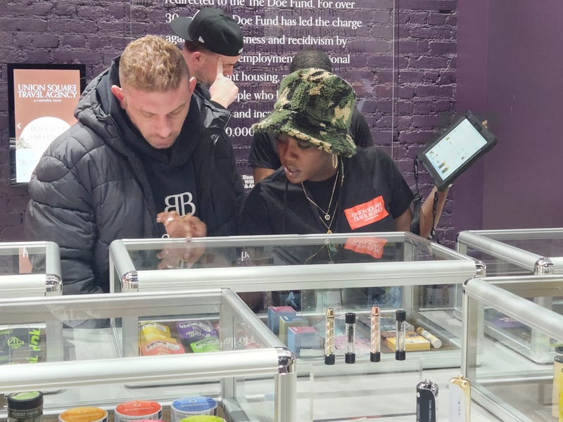 A budtender recommends cannabis products to a customer at the grand opening of USTA on Monday.