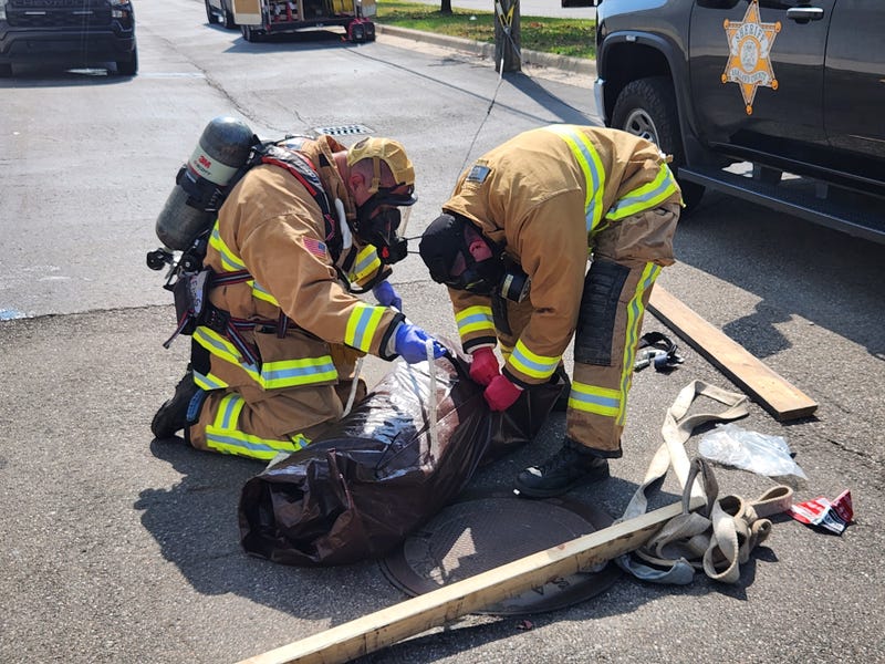 Authorities removing dog's body from grease pit