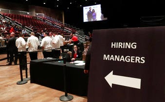 FILE - In this Sept. 18, 2019, file photo job applicants looks at jobs available at Florida International University during a job fair in Miami. (AP Photo/Lynne Sladky, File)