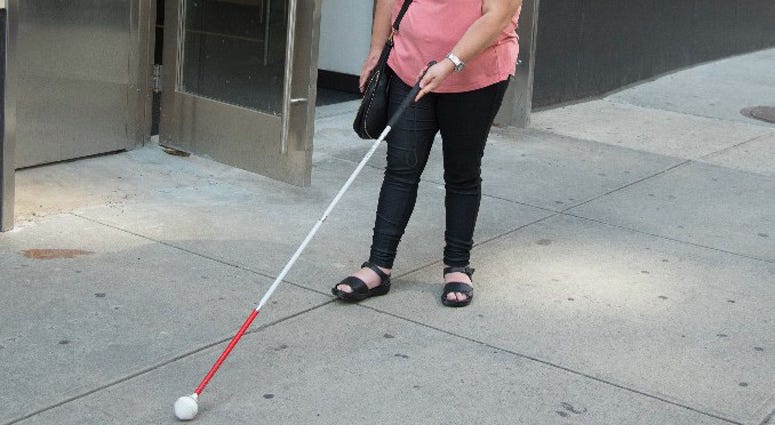Visually impaired person using a cane
