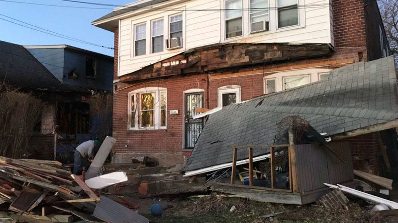 A car crashed into this and other houses, causing one to catch fire.