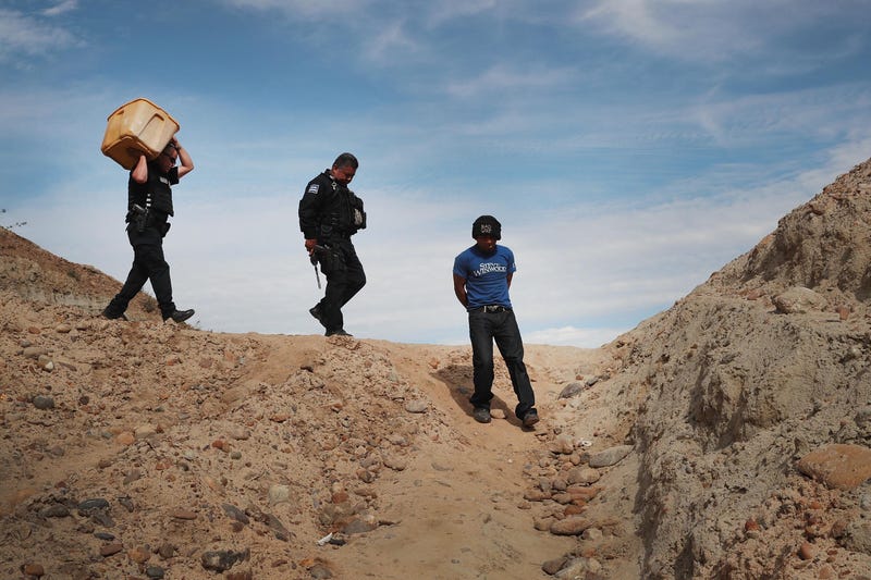 A migrant is taken into custody by Mexican police