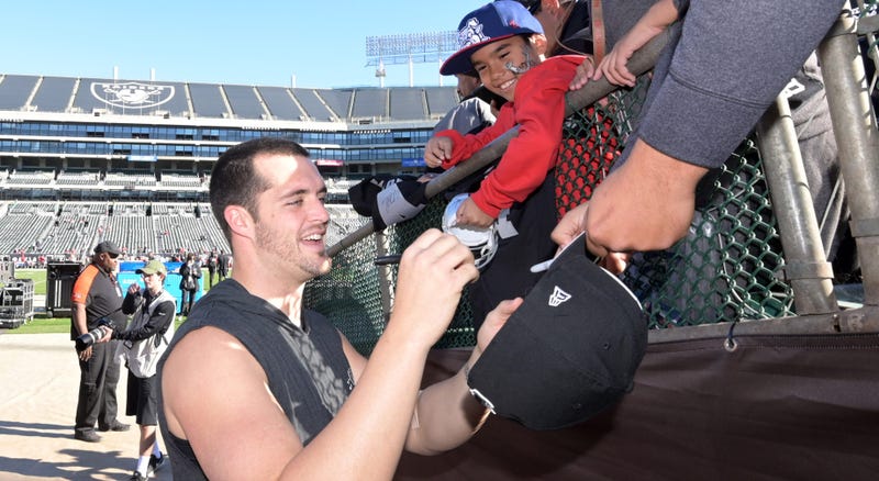 Dec 2, 2018; Oakland, CA, USA; Oakland Raiders quarterback Derek Carr (4) signs autographs before the game against the Kansas City Chiefs at Oakland-Alameda County Coliseum. Mandatory Credit: Kirby Lee-USA TODAY Sports