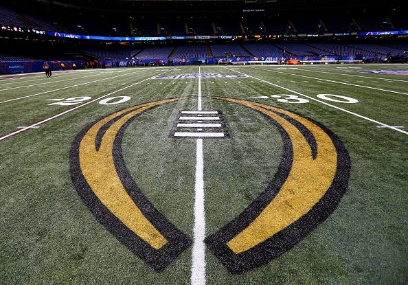 The College Football Playoff logo on the field of the Superdome. 
