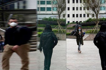 People wearing protective face masks, walk on a street in the Central, the business district of Hong Kong, Tuesday, Feb. 11, 2020. (AP Photo/Kin Cheung)