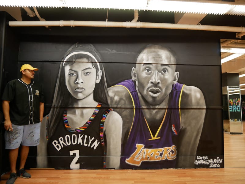 Andaluz The Artist standing in front of his Gigi and Kobe Bryant mural.