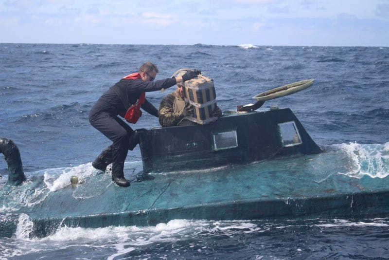 U.S. Coast Guard boarding team members climb aboard a suspected smuggling vessel.