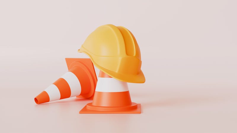 Orange helmet and traffic cones on a pastel color background - stock photo