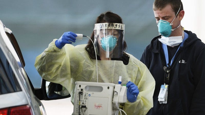 Medical staffers at UNC Hospitals in Chapel Hill, N.C., screen a patient at a drive-thru COVID-19 screening site outside the emergency department.
