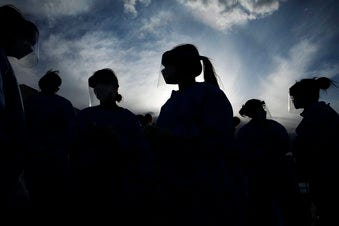 In this Saturday, March 28, 2020 file photo, medical and physician assistant students wear personal protective equipment as they prepare to screen for possible coronavirus cases at a makeshift camp for the homeless in Las Vegas.(AP Photo/John Locher)
