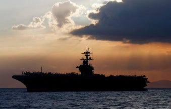 FILE - In this April 13, 2018, file photo the USS Theodore Roosevelt aircraft carrier is anchored off Manila Bay west of Manila, Philippines. (AP Photo/Bullit Marquez, File)
