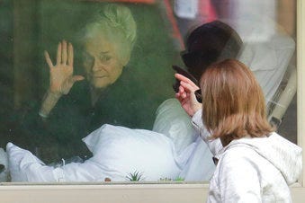 Judie Shape, left, who has tested positive for the coronavirus, waves to her daughter, Lori Spencer, right, Wednesday, March 11, 2020, at the Life Care Center in Kirkland, Wash. (AP Photo/Ted S. Warren)