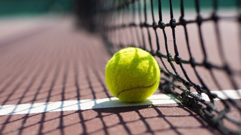 Tennis ball lying on the court - stock photo