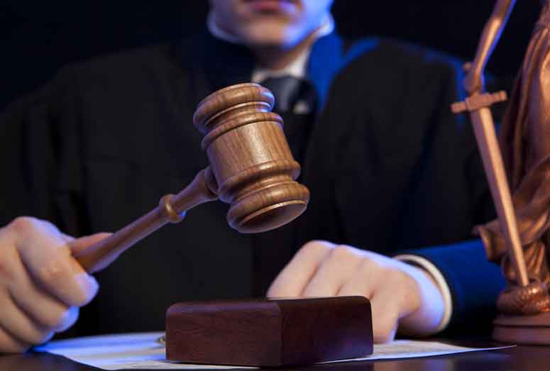 Male judge in a courtroom striking the gavel
