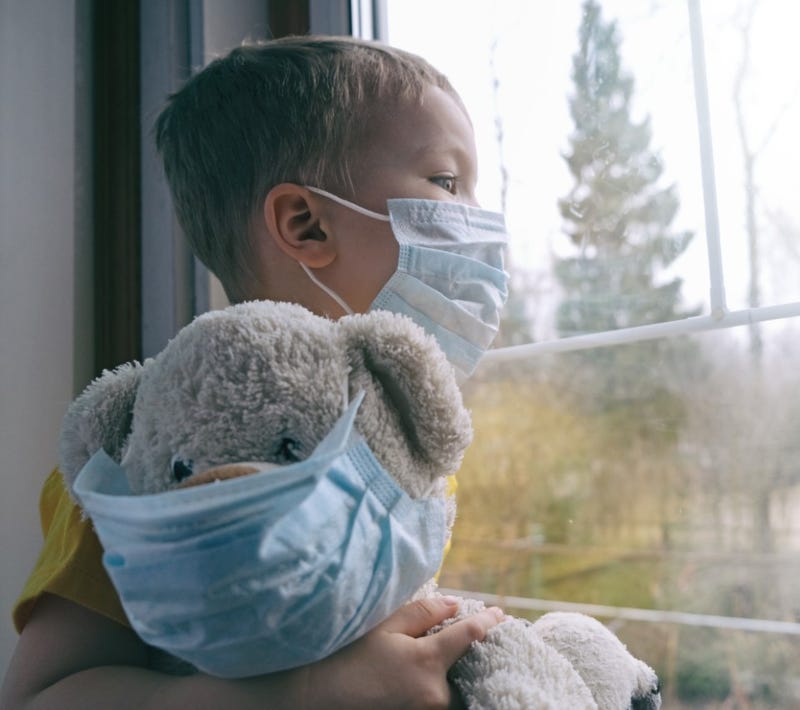  Boy and his teddy bear both in protective medical masks