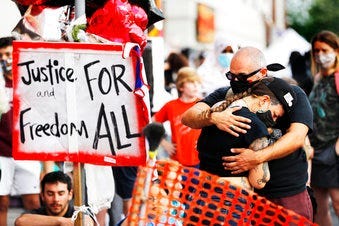 FILE - In this June 3, 2020, file photo, people gather at the site where George Floyd died in Minneapolis. (AP Photo/Julio Cortez, File)