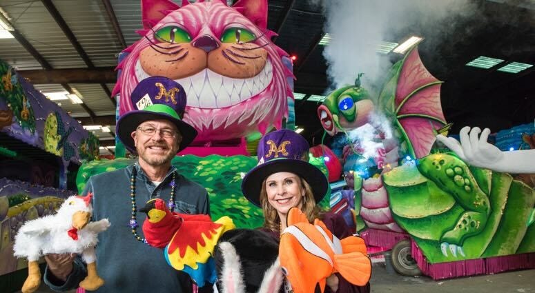 Captains Joey & Gwen Lacoste of MadHatters in front of a colorful float. 