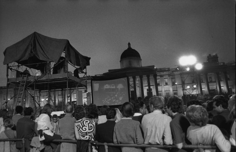 Crowds watching pictures of the first landing on the moon on a large screen in Trafalgar Square, London.