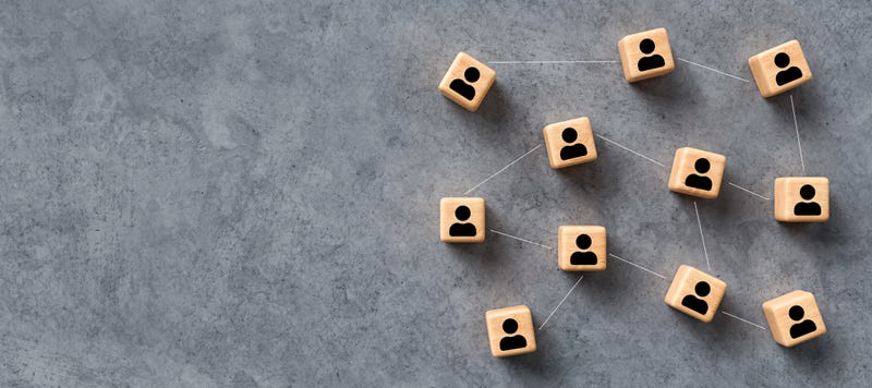 cubes with people symbols and connections between them on concrete background