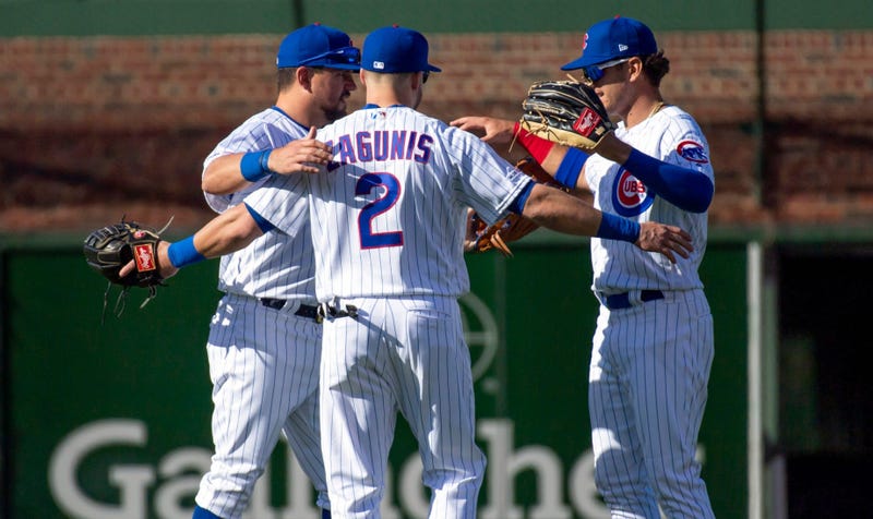 The Cubs outfield celebrates after a victory against the Pirates in their home opener.