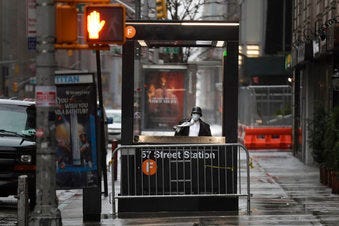 A man enters the subway on a rainy day in New York, Monday, April 13, 2020. Gov. Andrew Cuomo says New York's death toll from coronavirus has topped 10,000, with hospitals still seeing 2,000 new patients a day. (AP Photo/Seth Wenig)