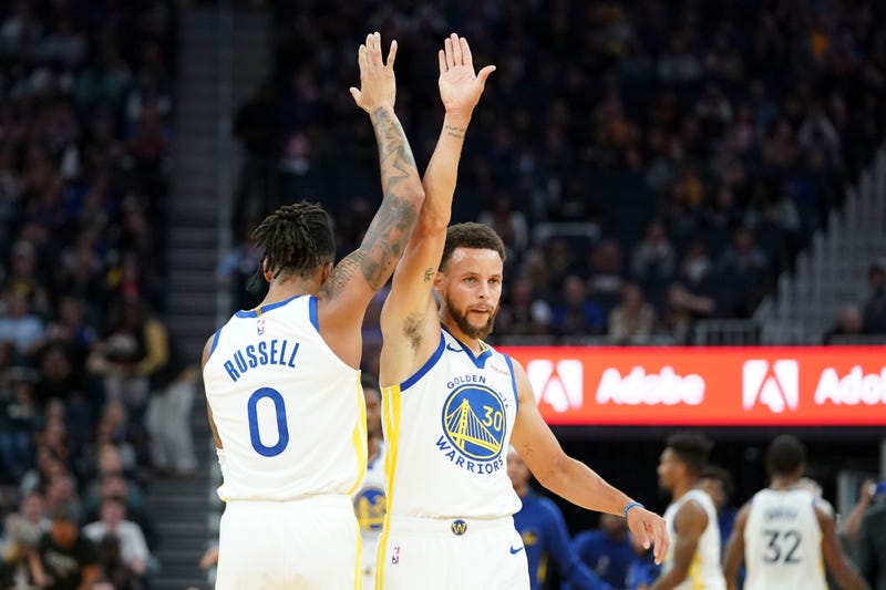 Stephen Curry high-fives new teammate D'Angelo Russell. 