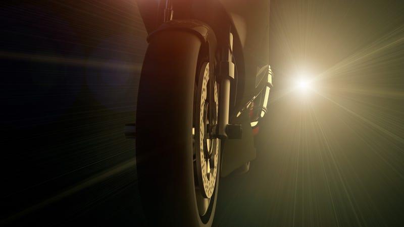 A motorcycle and bright light at night - stock photo